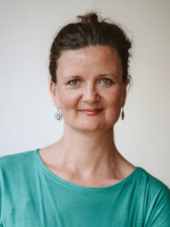 Portrait von Frau in grünem T-Shirt, lächelt in die Kamera